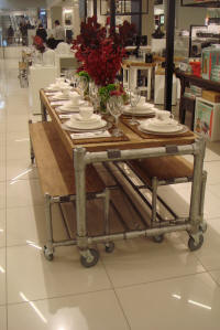 Banken met tafel op wielen van steigerbuizen en steigerhout.